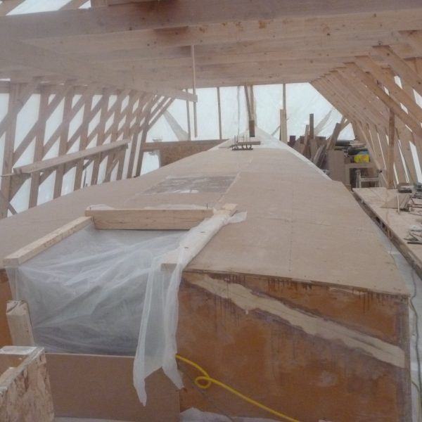The aft cabin top is on with the companionway opening draped in plastic.