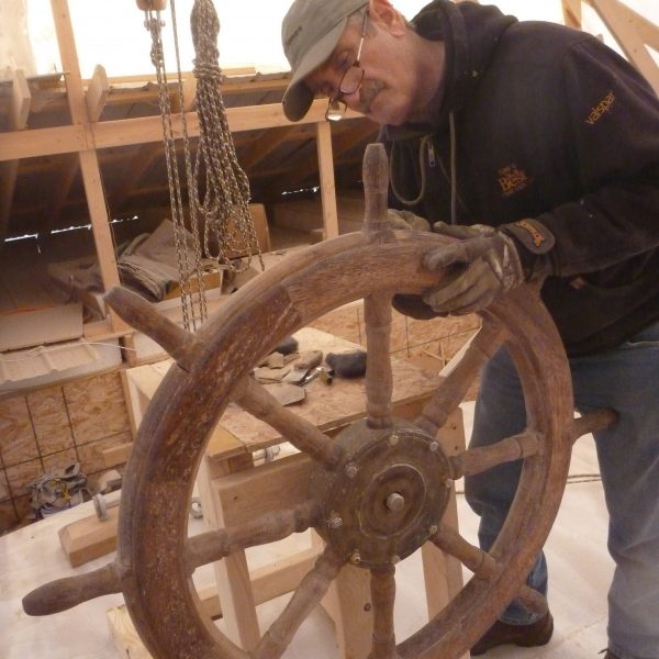 Judge MacDonald gives the teak ship’s wheel special attention.